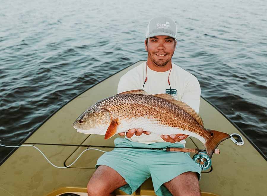 A man proudly holds a large fish caught during a Saltwater Fishing Charters trip, showcasing the successful catch. The image emphasizes the fishing experience offered by Saltwater Fishing Charters, aligning with the website's focus on providing memorable fishing adventures and detailed information about the services available.