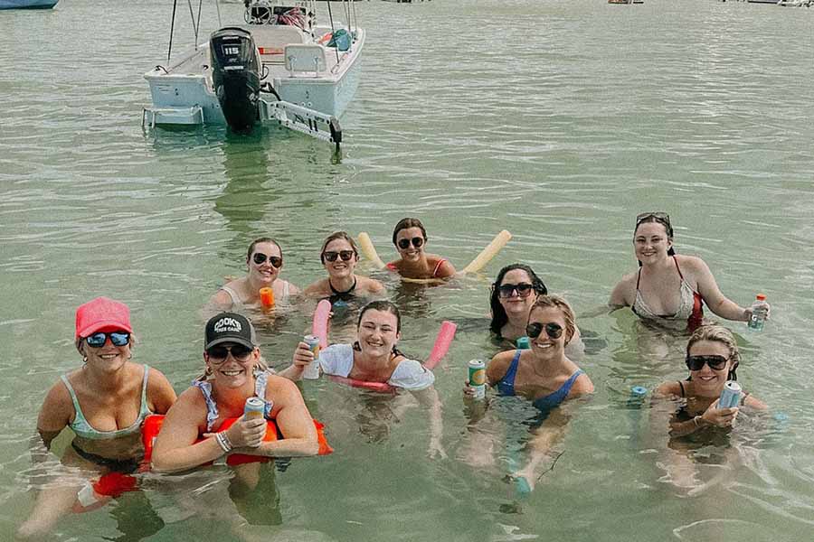 Women enjoying swimming in the ocean during a Saltwater Fishing Charters trip, illustrating the recreational activities available. The image highlights the fun and relaxation offered on these charters and aligns with the website's focus on providing information about cruise rates and services.