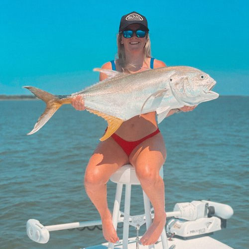 Image of a woman holding a fish, featuring Saltwater Fishing Charters and highlighting the ultimate fishing experience, capturing the excitement and success of their trips.