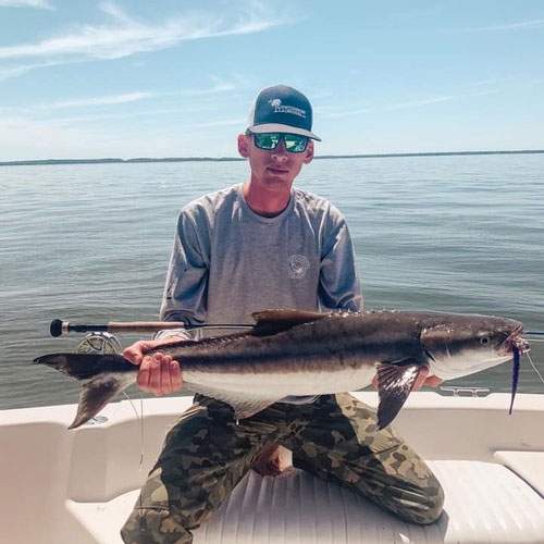 Image of a man holding a fish, featuring Saltwater Fishing Charters and highlighting the ultimate fishing experience, capturing the excitement of their charters.