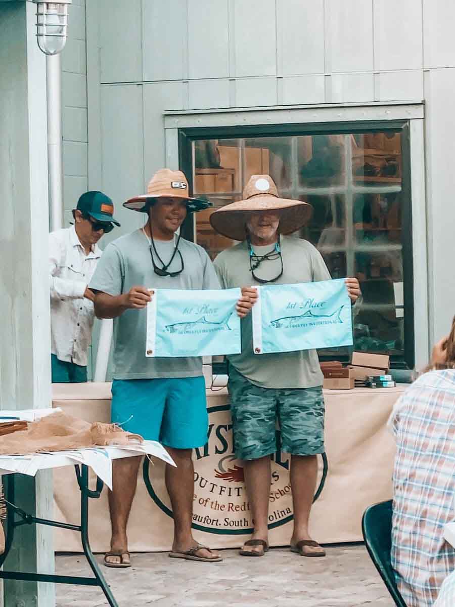 Two men proudly display an award they received from Saltwater Fishing Charters, celebrating their achievement. The image highlights the recognition and success associated with Saltwater Fishing Charters, aligning with the website's focus on showcasing its premier fishing services and accomplishments.