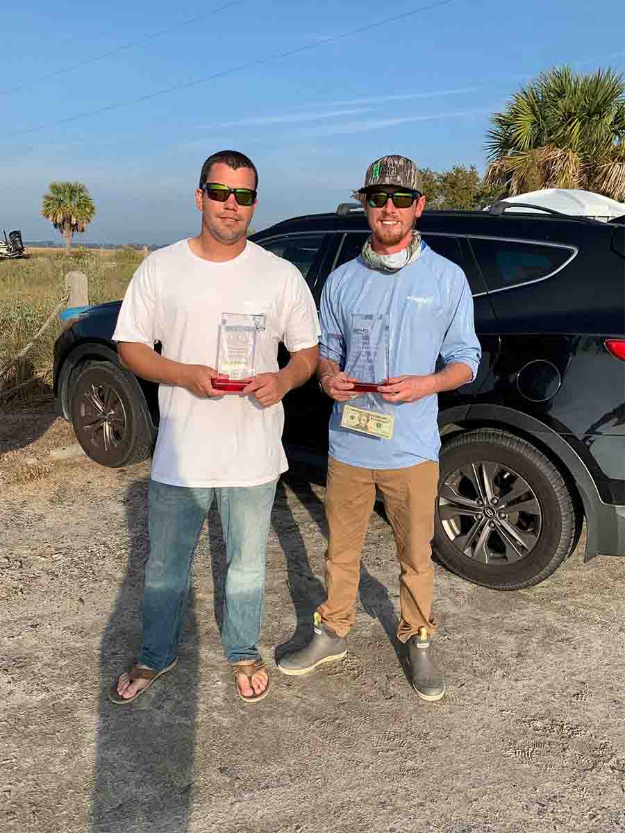 Two men proudly display an award they received from Saltwater Fishing Charters, celebrating their achievement. The image highlights the recognition and success associated with Saltwater Fishing Charters, aligning with the website's focus on showcasing its premier fishing services and accomplishments.